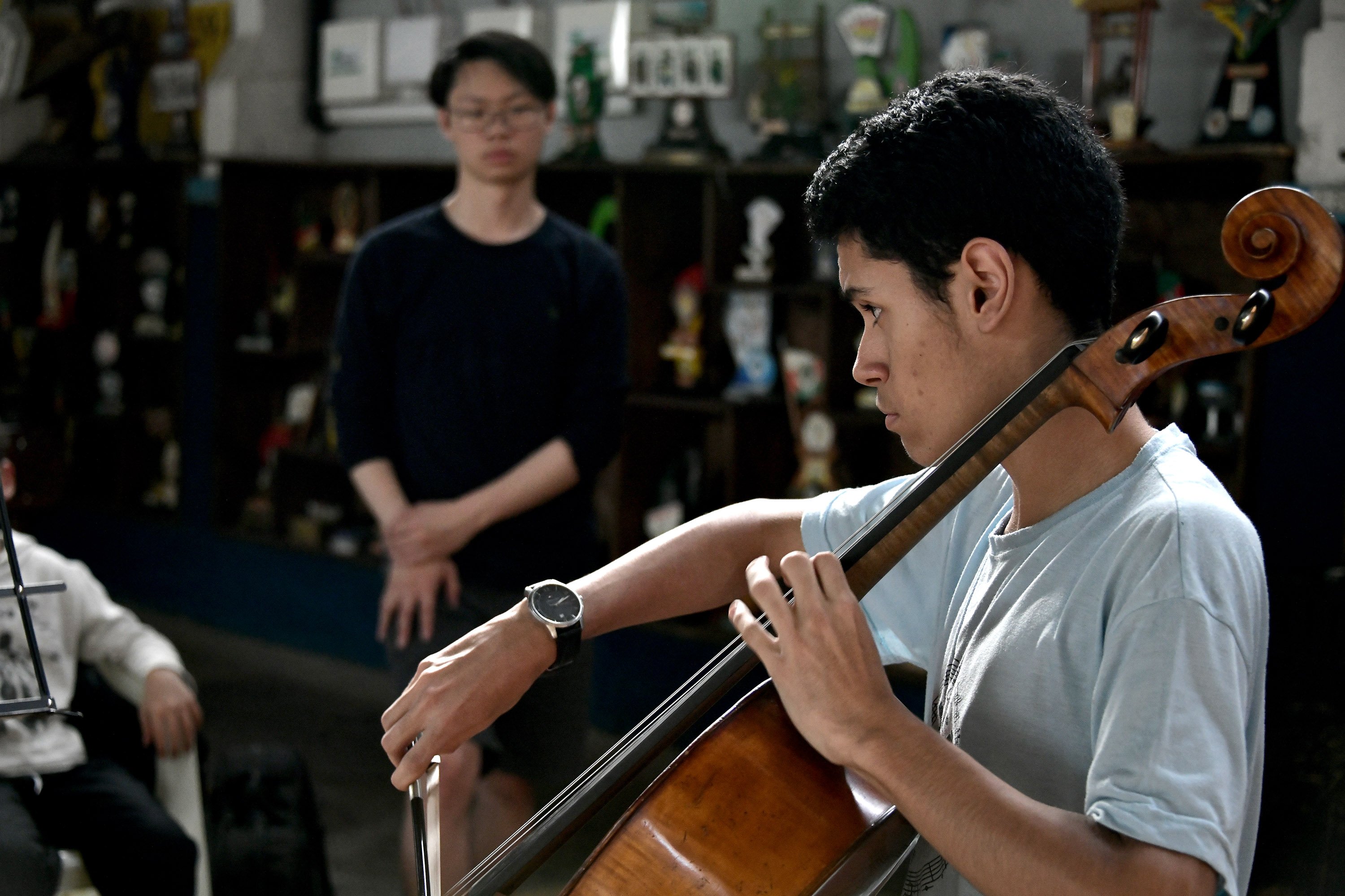 BPYO principal cellist Zach Fung watches a solo performance by IPDAE cellist