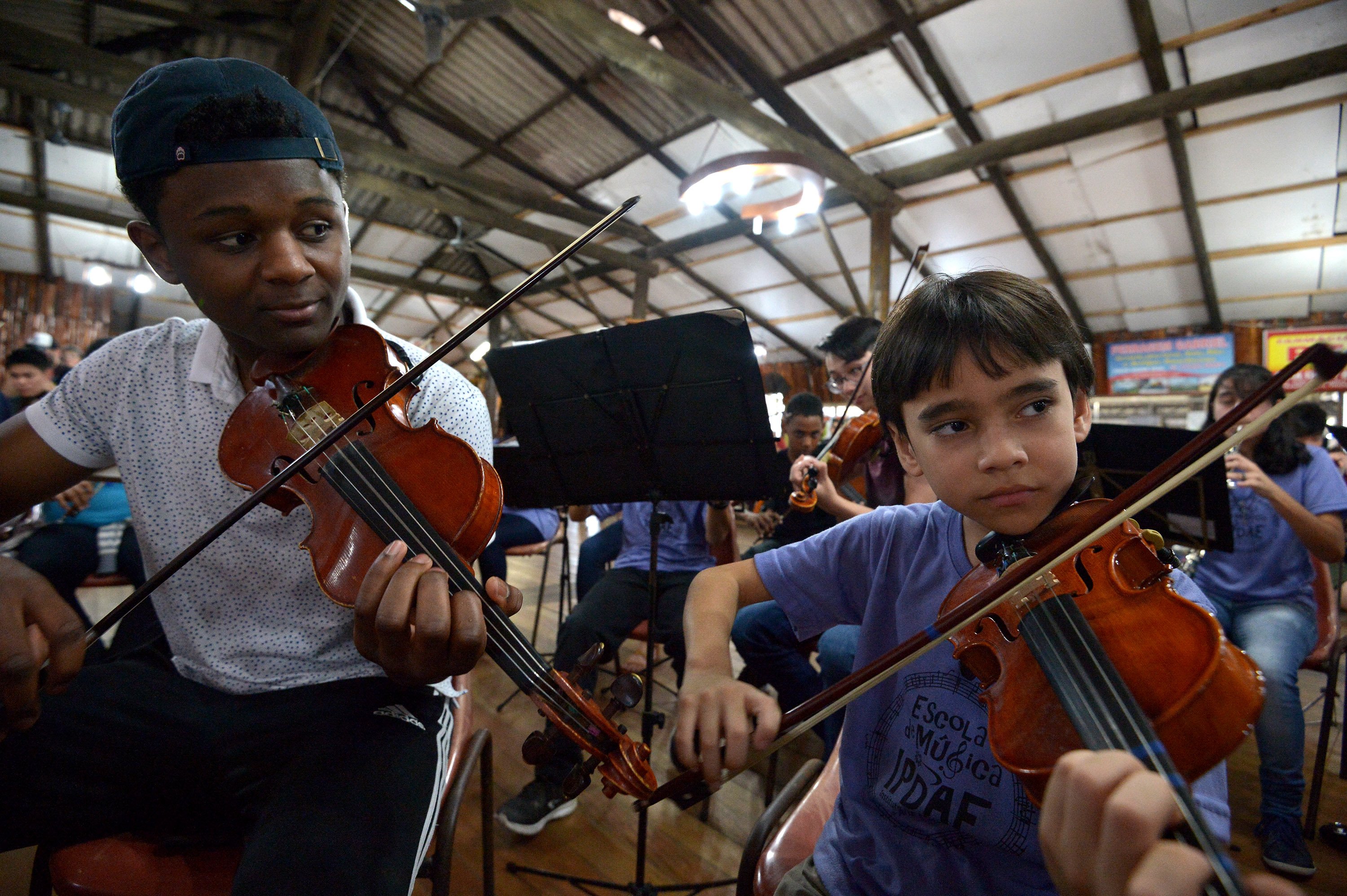 BPYO violinist Kerby Roberson with an eight-year-old colleague in Porto Alegre