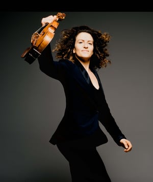 Liza Ferschtman triumphantly holding up her violin 